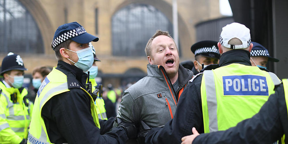 Ein Mann wird während einer Demonstration von Polizisten weggeführt. Foto: Stefan Rousseau/PA Wire/dpa