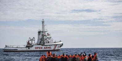 ARCHIV - Flüchtlinge die auf einem Schlauchboot im Mittelmeer treiben, freuen sich über die Ankunft eines Schiffes der spanischen Nichtregierungsorganisation "Pro Activa Open Arms". Foto: Javier Fergo/AP/dpa