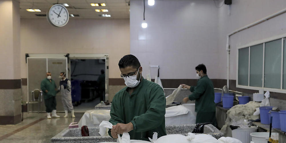 dpatopbilder - Ein Mitarbeiter bereitet in einem Leichenschauhaus in Teheran den Leichnam eines Mannes vor, der an den Folgen einer Corona-Infektion gestorben ist. Foto: Ebrahim Noroozi/AP/dpa