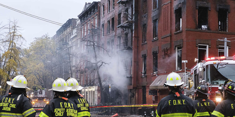 Feuerwehrleute stehen für Löscharbeiten vor dem Gebäude der «Middle Collegiate Church». Ein gewaltiges Feuer hat eine historische Kirche in dem New Yorker Stadtteil East Village weitgehend zerstört. Foto: Yuki Iwamura/FR171758 AP/dpa