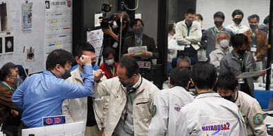 HANDOUT - Die Projektteilnehmer jubeln in einem Kontrollraum des JAXA-Campus Sagamihara, nachdem die erfolgreiche Trennung einer Kapsel vom Raumschiff Hayabusa2 bestätigt wurde. Foto: -/JAXA/AP/dpa