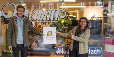 Andy Zünd von der Agentur Machart und Silvia Hermann-Segmüller, Leiterin der Reburg, mit dem neuen Logo des Familien-und Begegnungszentrums (Bild: zVg)