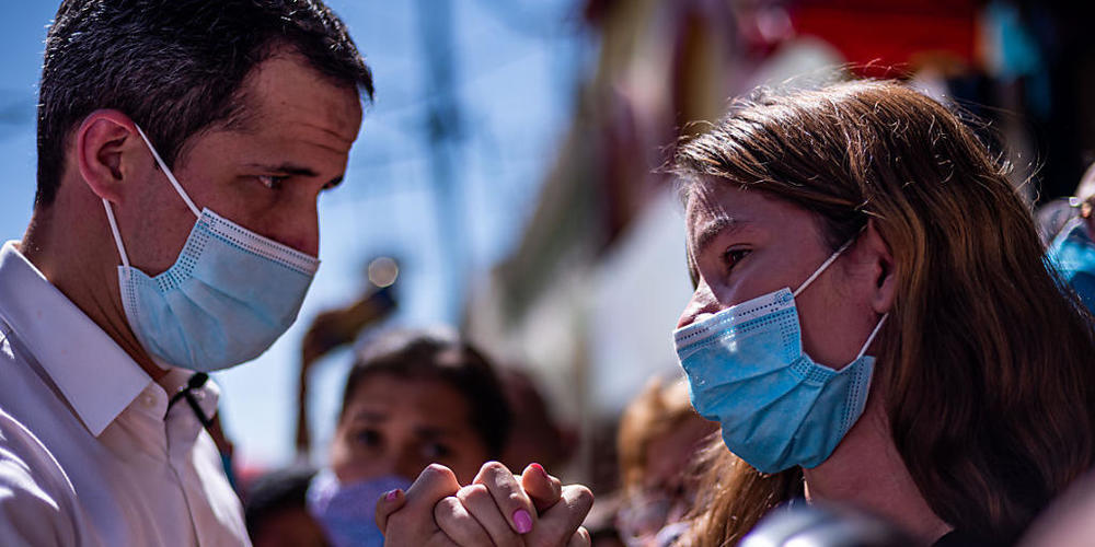 Juan Guaido, Oppositionsführer und selbst ernannter Interimspräsident, hält bei einem Auftritt die Hand einer Unterstützerin. Foto: Elena Fernandez/ZUMA Wire/dpa