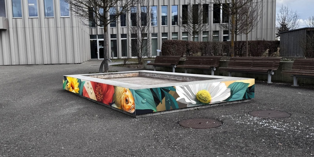 Seit 2024 lädt der Gemeindehausplatz mit seinen Holzsitzmöbeln und den roten Sonnensegeln zur Auszeit  ein.
