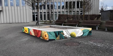 Seit 2024 lädt der Gemeindehausplatz mit seinen Holzsitzmöbeln und den roten Sonnensegeln zur Auszeit  ein.