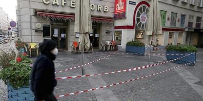 Ein Mann mit Mund-Nasen-Schutz geht an einem geschlossenen Cafe in der Innenstadt vorbei. In Österreich sind seit Anfang November wegen der drohenden Überfüllung der Intensivstationen in der Corona-Pandemie Kultur, Gastronomie und Freizeiteinricht...