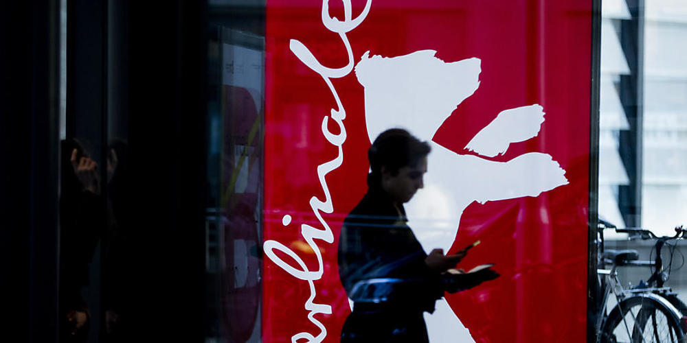 70. Berlinale, eine Frau geht an einem Berlinale-Plakat vorbei. Archivbild. Foto: Christoph Soeder/dpa