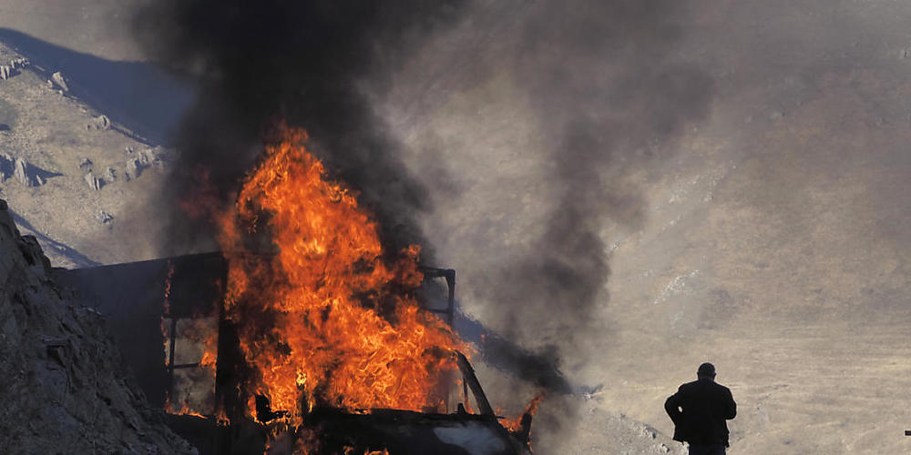 ARCHIV - Ein brennendes Auto nahe der Grenze zwischen Berg-Karabach und Armenien. Foto: ---/AP/dpa