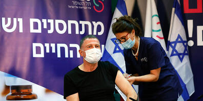 Eine Mitarbeiterin in einem Krankenhaus impft den israelischen Gesundheitsminister Juli Edelstein. Foto: Amir Cohen/POOL Reuters/AP/dpa