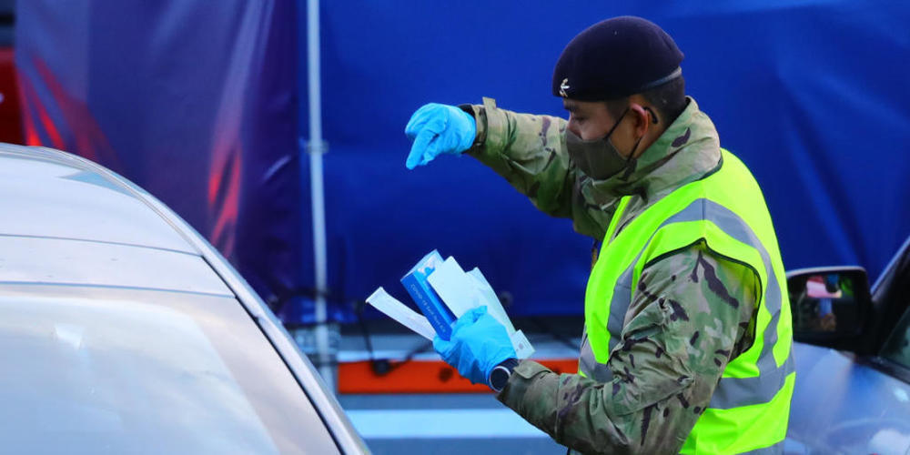Ein Mann führt einen Corona-Test bei einer im Auto sitzenden Person am Hafen von Dover durch. Die britische-französisch Grenze soll über die Weihnachtsfeiertage offen bleiben und der Verkehr durch den Eurotunnel soll weitergehen. Foto: Aaron Chown...