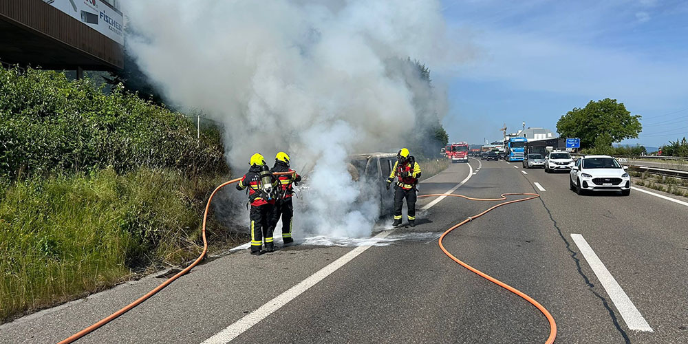 Ein Auto hat Feuer gefangen. Die Löscharbeiten laufen.