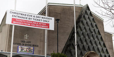 Vor der Kirche Our Lady Mother of Divine Grace weist ein Schild darauf hin, dass der Eintritt zu den Weihnachtsgottesdiensten nur mit einer Eintrittskarte möglich ist. Foto: Brian Lawless/PA Wire/dpa
