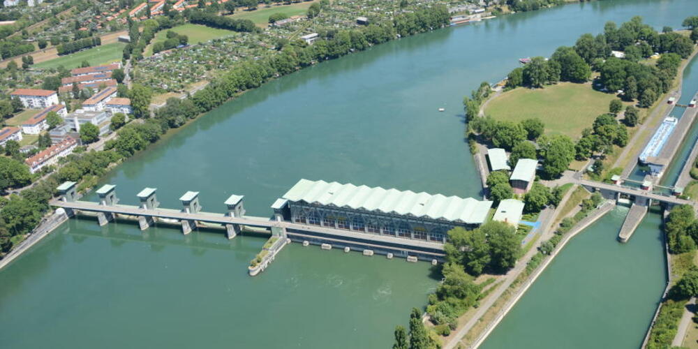 Das Wasserkraftwerk im Rhein in Birsfelden BL (links) mit der Kraftwerkinsel (Mitte) und der Schleuse (rechts) aus West-Süd-West.