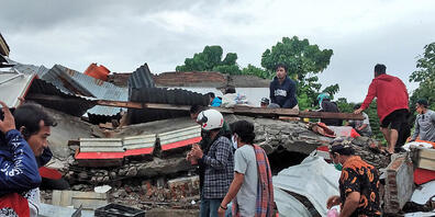 Anwohner auf der Insel Sulawesi inspizieren ein zerstörtes Haus. (Bild: Yusuf Wahil/AP/dpa/Keystone)