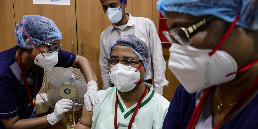 In Kolkata erhält eine Mitarbeiterin des Gesundheitswesens eine Impfung gegen das Coronavirus. Foto: Bikas Das/AP/dpa