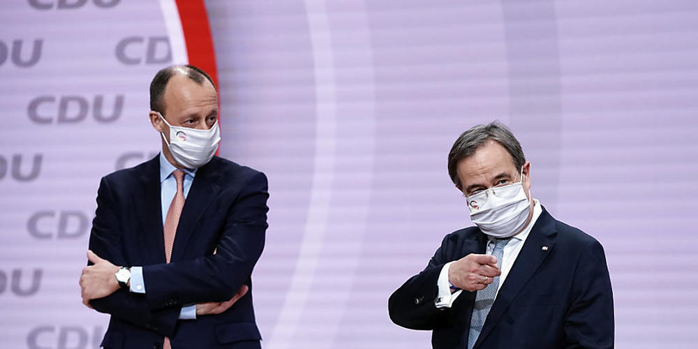 Der unterlegene Friedrich Merz (l) steht neben Abstimmunssieger Armin Laschet beim digitalen CDU-Bundesparteitag auf dem Podium. Foto: Michael Kappeler/dpa