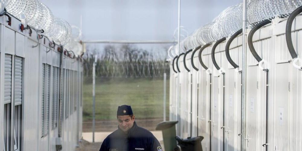 ARCHIV - Ein ungarischer Polizist patrouilliert durch das Internierungslager für Asylsuchende an der Grenze zu Serbien. Foto: Sandor Ujvari/MTI/AP/dpa