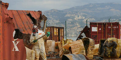 Ein Arbeiter entfernt im zerstörten Hafen von Beirut Behälter mit Salzsäure aus verrotteten Containern. Foto: Marwan Naamani/dpa