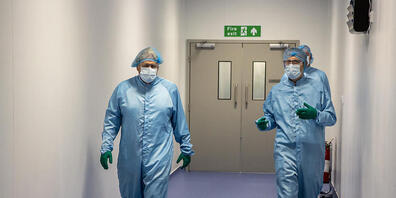 Boris Johnson (l), Premierminister von Großbritannien, geht mit Simon Simpkins, Produktionsleiter bei Oxford Biomedica, während eines Rundgangs durch die Produktionsanlage für den Corona-Impfstoff von Oxford/Astrazeneca bei Oxford Biomedica. Foto:...