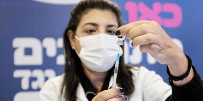 Eine Krankenschwester zieht eine Spritze für die Coronaimpfung eines älteren Mannes im Impfzentrum "Pais Arena Sports Complex" auf. Weniger als zwei Wochen nach Beginn einer Impfkampagne im Rekord-Tempo hat Israel schon fast eine Million seiner Bü...