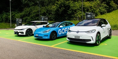 Mehrere Elektroautos laden an öffentlich zugänglichen Ladestationen, die Teil des wachsenden Schweizer Ladenetzes sind.