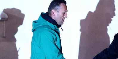 Alexej Nawalny, Oppositionspolitiker und Kremlkritiker, wird von einem Polizeibeamten vor der 2. Abteilung der Direktion des russischen Innenministeriums von Chimki eskortiert. Foto: Sergei Bobylev/TASS/dpa