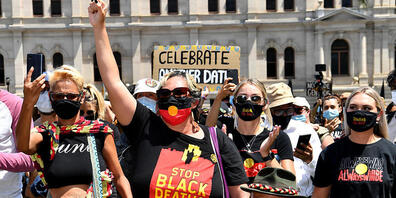 Protestors are seen during an Invasion Day rally in Brisbane, Tuesday, January 26, 2021. Australia Day 2021 has been marked by debates about changing the date or abolishing the holiday, Australia Day honours, and whether rallies should go ahead.(A...