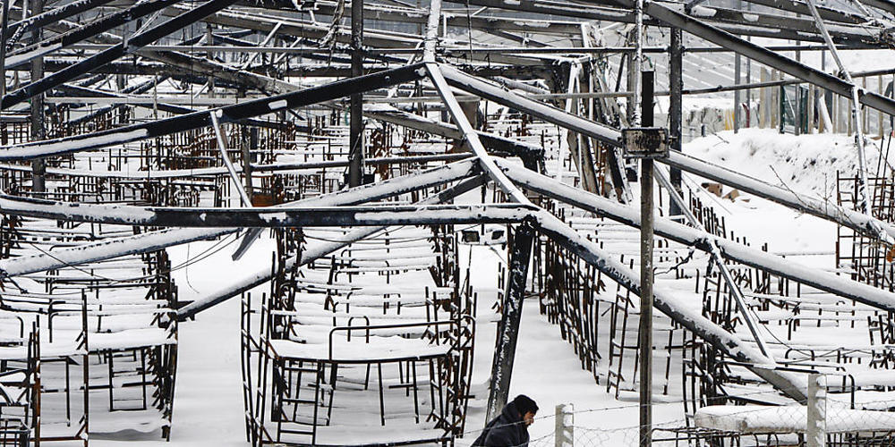 Ein Migrant geht durch den Schnee im abgebrannten Lager Lipa. Foto: Kemal Softic/AP/dpa