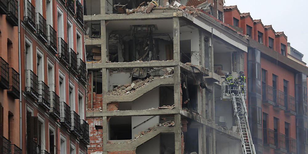Feuerwehrleute arbeiten nach der schweren Explosion an dem beschädigten Gebäude in Madrids Toledo Straße. Foto: Manu Fernandez/AP/dpa