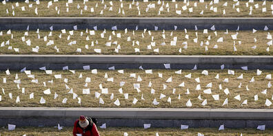 dpatopbilder - Ein Mann platziert Flaggen im National World War I Museum and Memorial in Gedenken an die Bewohner der Region, die bei der Coronavirus-Pandemie ums Leben kamen. Foto: Charlie Riedel/AP/dpa