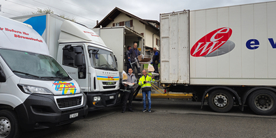 Roland Schirmer, Andreas Kümin und Mitarbeitende von Mc PaperLand beim Umladen der Möbel in den Rumänischen Lastwagen 