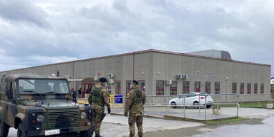 Polizisten stehen vor einem speziell konstruierten Bunker, in dem Mitte Januar der Prozess gegen rund 350 mutmaßliche Mitglieder und Helfer der Mafia-Organisation 'Ndrangheta stattfand. Foto: Andrea Rosa/AP/dpa