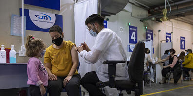 Eine israelische Frau bekommt von einer medizinischen Fachkraft in einem Impfzentrum eine Impfdosis mit dem Corona-Impfstoff von Biontech/Pfizer. Foto: Oded Balilty/AP/dpa