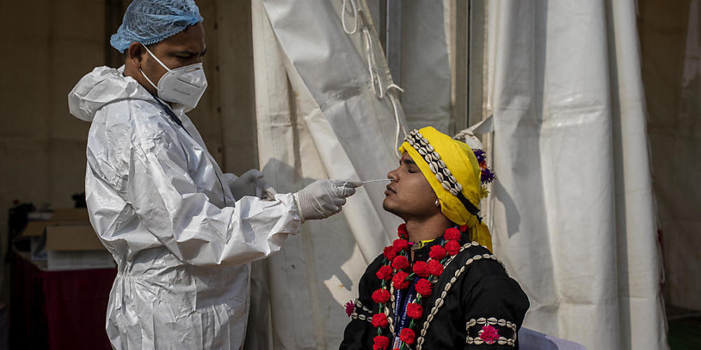 Ein Mitarbeiter des Gesundheitswesens macht in Indiens Hauptstadt Neu-Delhi einen Abstrich für einen Corona-Test. Foto: Altaf Qadri/AP/dpa