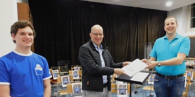 Die Vertreter der Musikvereine überreichen Gemeindepräsident Lucas Keel die Petition für ein neues Probelokal:  rechts im Bild Raphael Lusti, Präsident des Musikverein Uzwil-Henau, und links im Bild Christof Kraft, Vorstandsmitglied der Jugendmusik Uzwil.