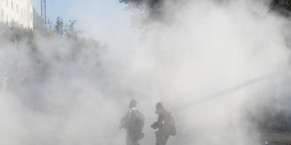 Zwei Personen stehen in einer dichten Tränengaswolke. Nach tödlichen Schüssen eines Polizisten auf einen Straßenkünstler ist es zu heftigen Ausschreitungen gekommen. Foto: Matias Basualdo/ZUMA Wire/dpa