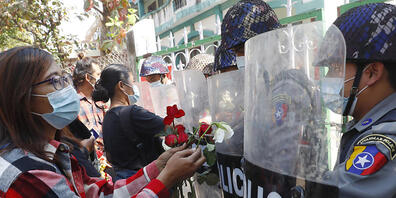 dpatopbilder - Demonstranten überreichen der Polizei Rosen, während vier festgenommene Aktivisten vor Gericht erscheinen. Hunderte von Studenten und Lehrern sind in Myanmar auf die Strasse gegangen, um zu fordern, dass das Militär die Macht an gew...