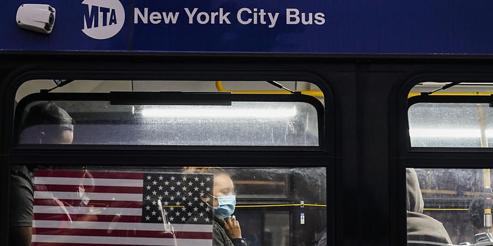 ARCHIV - Eine Frau trägt aufgrund der Corona-Pandemie einen Mund-Nasen-Schutz, während sie in einem Bus in New York sitzt. Foto: Frank Franklin Ii/AP/dpa
