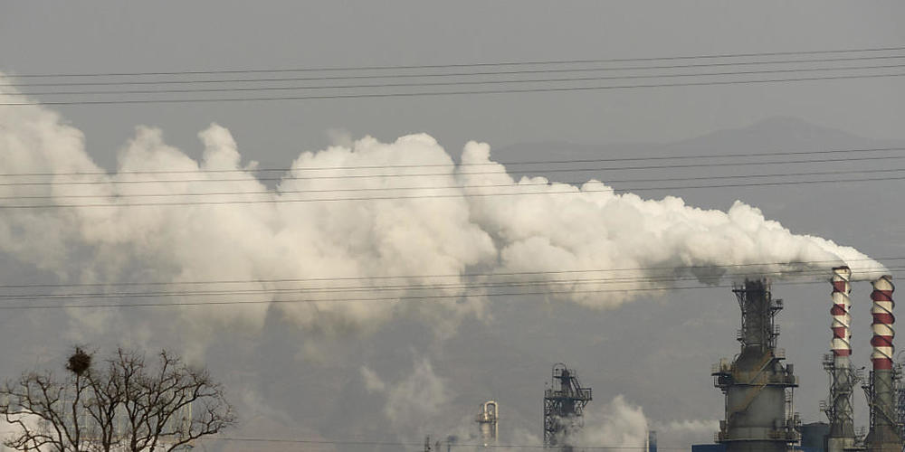 ARCHIV - Rauch und Dampf steigen von einer Kohleverarbeitungsanlage in der zentralchinesischen Provinz Shanxi auf, in der Ruß, ein Bestandteil der Stahlherstellung, hergestellt wird. Foto: Olivia Zhang/AP/dpa
