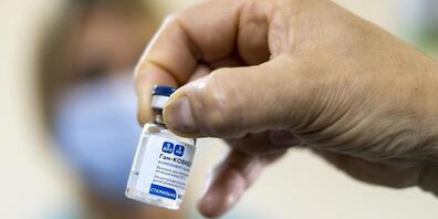 ARCHIV - Eine Person zeigt ein Fläschchen mit dem Impfstoff Sputnik V. Nach Kritik an fehlenden belastbaren Studien haben russische Forscher weitere Details zu dem Corona-Impfstoff Sputnik V veröffentlicht. Foto: Patricio Murphy/ZUMA Wire/dpa