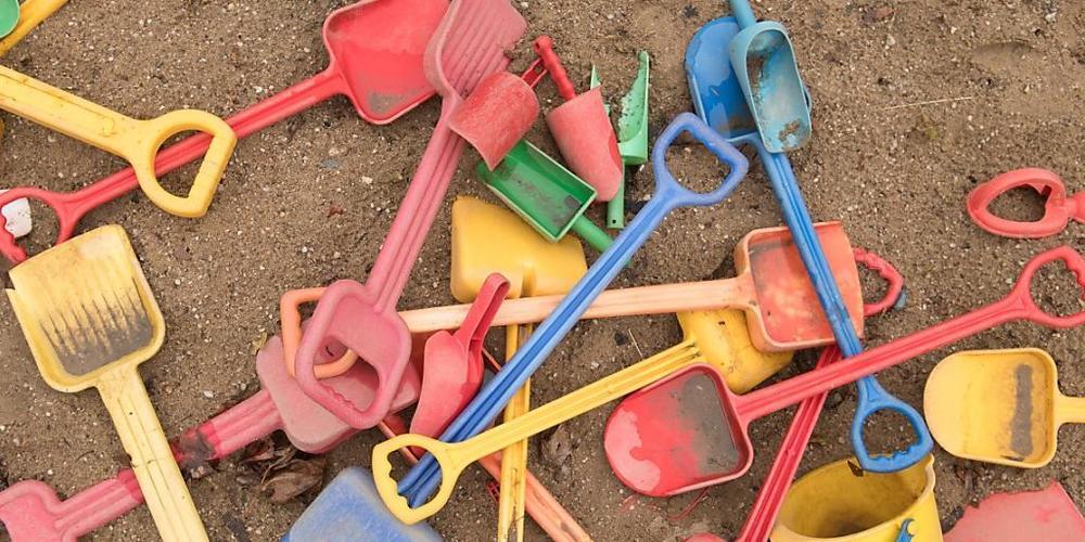 ARCHIV - Schaufeln und Eimer liegen auf einem Spielplatz in einem Sandkasten. Familien sollen zur Abfederung der Corona-Kosten in diesem Jahr erneut einen Kinderbonus erhalten. Foto: Sebastian Kahnert/dpa-Zentralbild/dpa