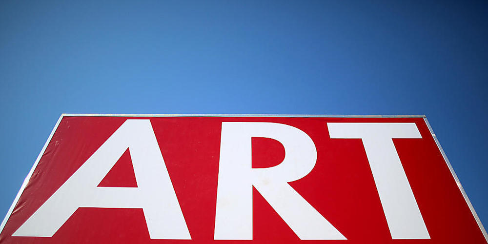 ARCHIV - Ein Plakat der Art Cologne steht vor der Messe. Die größte deutsche Kunstmesse, die Art Cologne, fand zum letzten Mal im April 2019 statt - der neue Termin für dieses Jahr ist jetzt der 17. bis 21. November. Zwischen den beiden Ausgaben l...