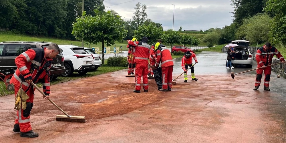 Die Feuerwehr bindet ausgelaufene Betriebsstoffe auf dem Parkplatz.