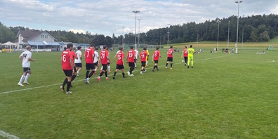 Spieler des SC Aadorf (weiss-schwarz) und des FC Uznach (rot-schwarz) beim Einlaufen auf dem Spielfeld.
