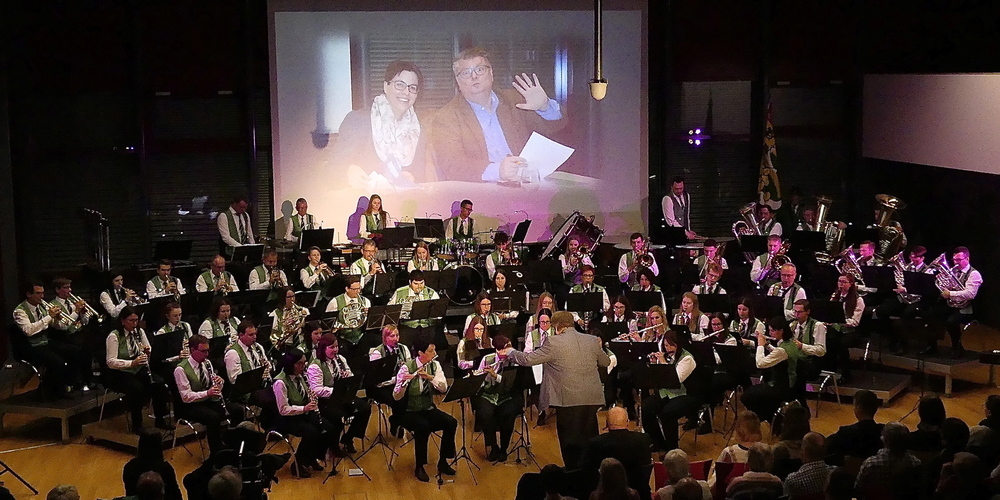 Die Musikgesellschaft Montlingen-Eichenwies bei einem der grossartigen Galakonzerte. Von der Leinwand winken Präsidentin Irene Loher und Matthias Beno