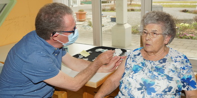 Pflegedienstleiter Jörg Schumacher des Alters- und Pflegeheims Rheinauen impft Bewohnerin Margrith Schawalder gegen Covid-19.