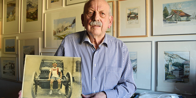 Adelbert Stähli – hier mit dem Bild seiner ersten Dienstzeit – in seinem Büro mit Bilderwand.