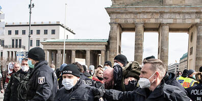 Ein Teilnehmer an einer Demonstration von Rechtsextremisten und sogenannten Reichsbürgern wird von der Polizei am Brandenburger Tor festgenommen. Foto: Paul Zinken/dpa