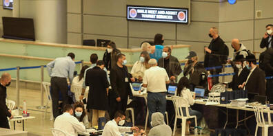 Passagiere des Flugs 232 aus Frankfurt der Fluggesellschaft Arkia Israeli Airlines werden bei der Ankunft am Flughafen Ben Gurion mit elektronischen Armbändern zur Überwachung ausgestattet. Foto: Ilia Yefimovich/dpa