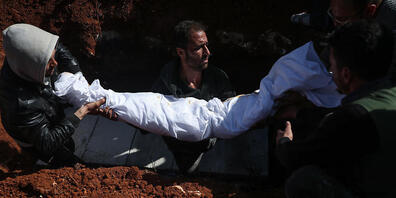 Syrische Männer tragen während einer Beerdigung auf einem Friedhof den Leichnam einer Person, die bei einem Raketenangriff auf ein Krankenhaus getötet wurden. In Syrien sind bei einem Angriff von Regierungstruppen auf ein Krankenhaus nach Angaben ...